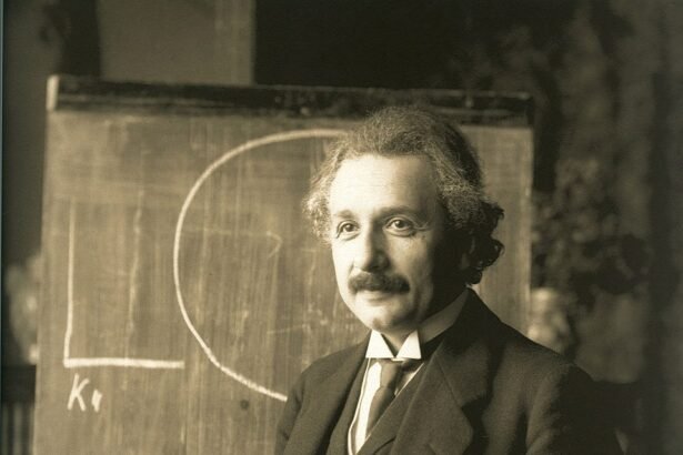 Albert Einstein áll egy táblánál, kezében krétával, tudományos magyarázatot ad.