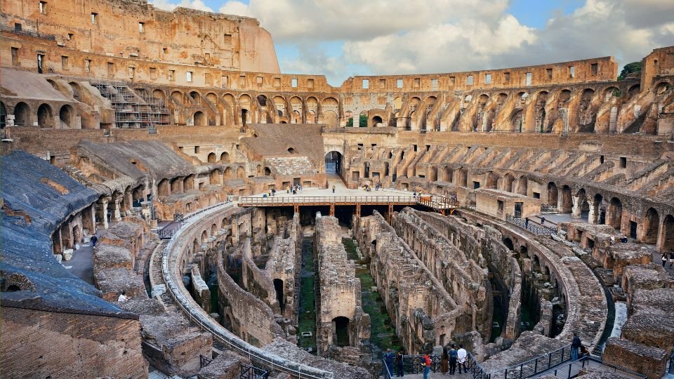 A Colosseum belső terének látképe, ahol az arénát körülvevő ülések és a föld alatti részek láthatók.