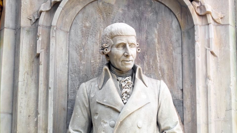 Egy szobor, amely Joseph Haydnt ábrázolja, részletes kidolgozással és elegáns öltözetben.