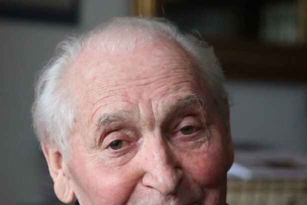 Idős férfi mosolyogva ül egy fotelben, barátságos arckifejezéssel.