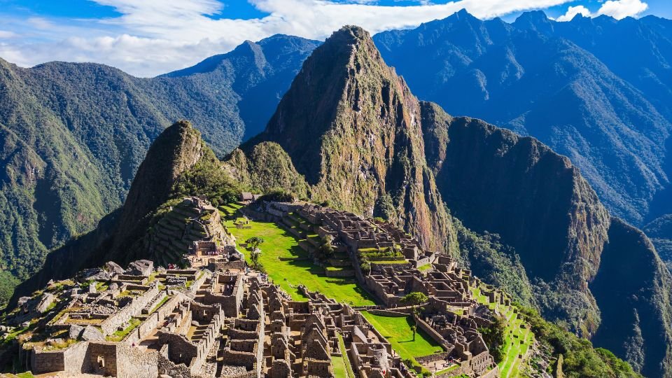 Machu Picchu romvárosa, a hegyek között elhelyezkedve, gyönyörű zöld területekkel.