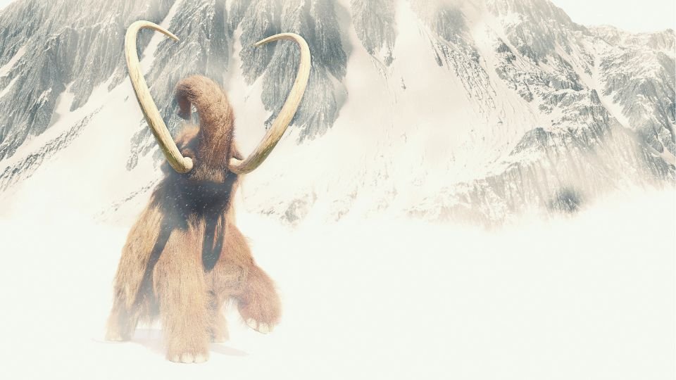 Egy mammut áll a havas hegyek előtt, a táj jégkorszakot idéz.