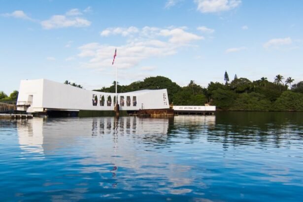 A Pearl Harbor-i USS Arizona emlékhely, amely a víz tükrében látható, zöld dombokkal körülvéve.