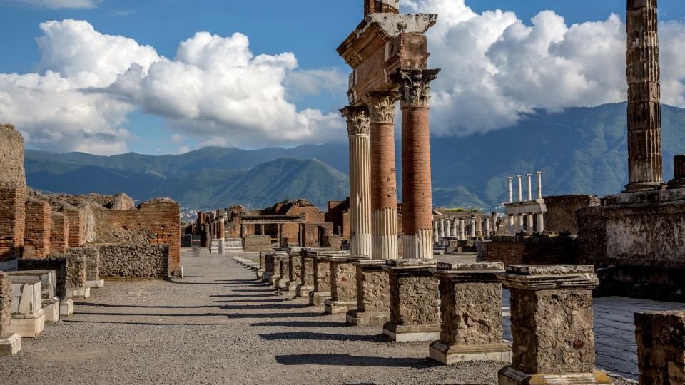Pompeji romjai, oszlopokkal és hegyekkel a háttérben.