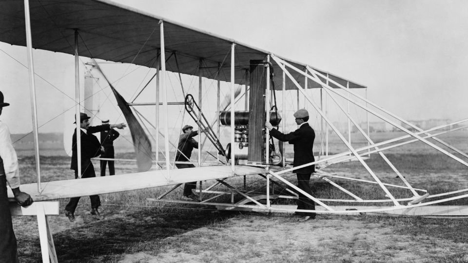 Wright testvérek korai repülőgépe, férfiak dolgoznak a gép körül.