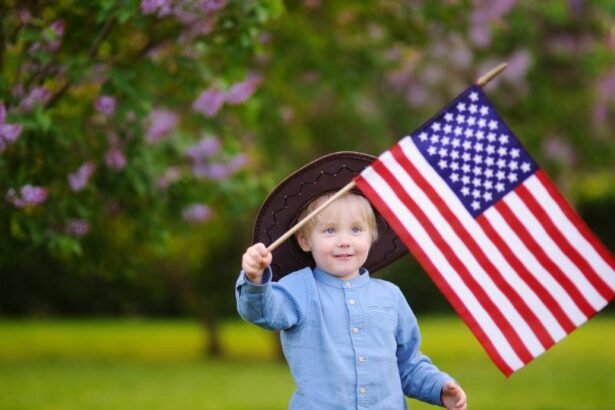 Egy kisfiú amerikai zászlót lenget egy virágzó fa alatt.