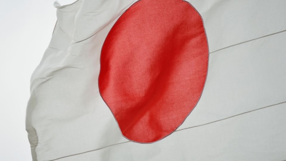 A japán zászló, fehér alapon piros körrel, szélben lobog.