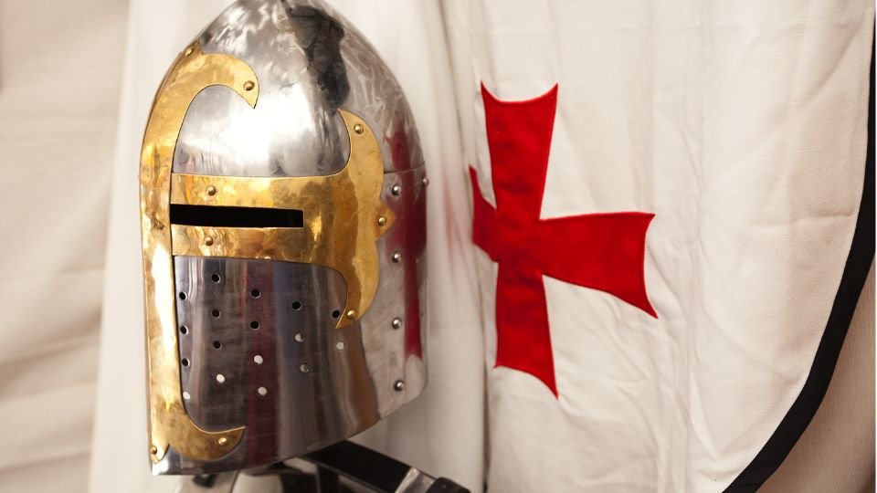 Egy templomos lovag sisakja és fehér köpeny piros kereszttel.