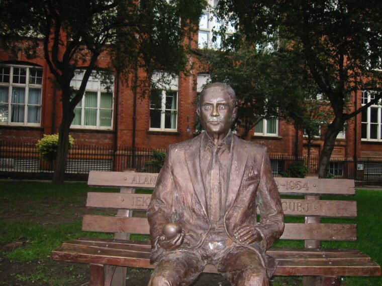 Alan Turing bronz szobra egy parkban, ülőhelyen.